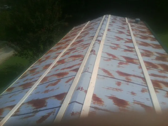 Rusted metal roof panels with new wood purlins before replacement in Saratoga